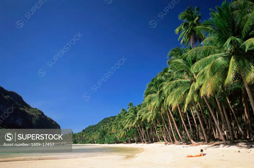 Philippines, Palawan, Bascuit Bay, El Nido, Girl Sunbathing on Tropical Beach