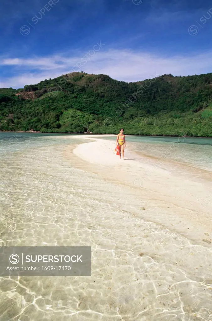 Philippines, Palawan, Bascuit Bay, El Nido, Girl Walking on Snake Island Sandbar with Tropical Beach in Background