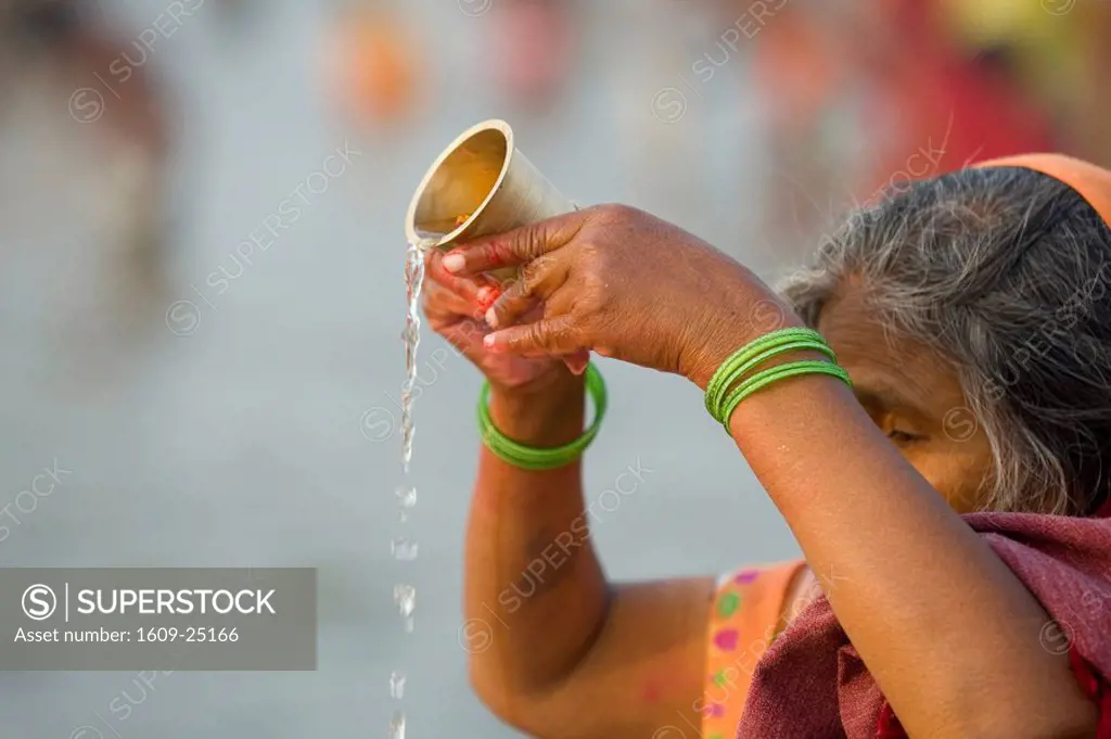 Woman carrying out puja hindu devotion by the river Ganges at Kumh Mela festival, Allahabad, Uttar Pradesh, India
