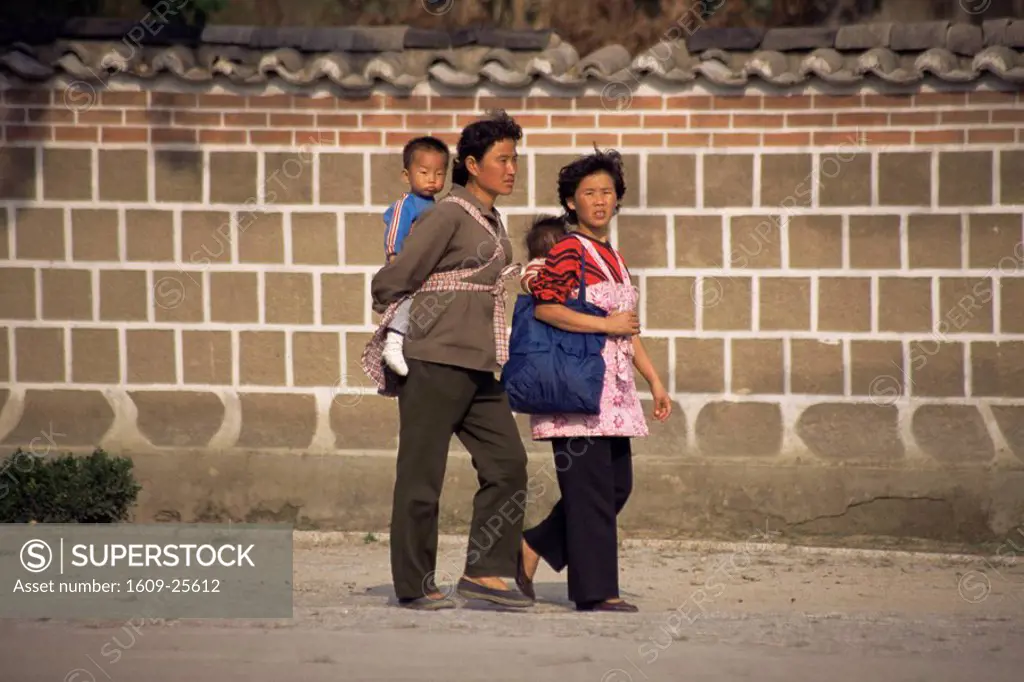 Family walking along street, Kaesong, North Korea