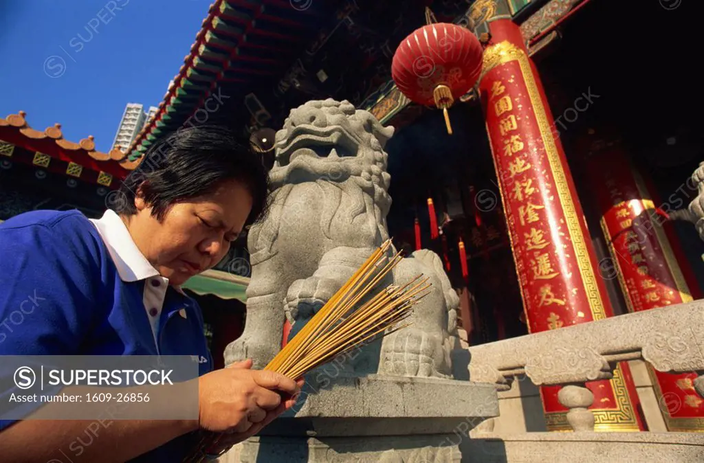 China, Hong Kong, Kowloon, Wong Tai Sin, Wong Tai Sin Temple, Woman Preying with Incense Sticks