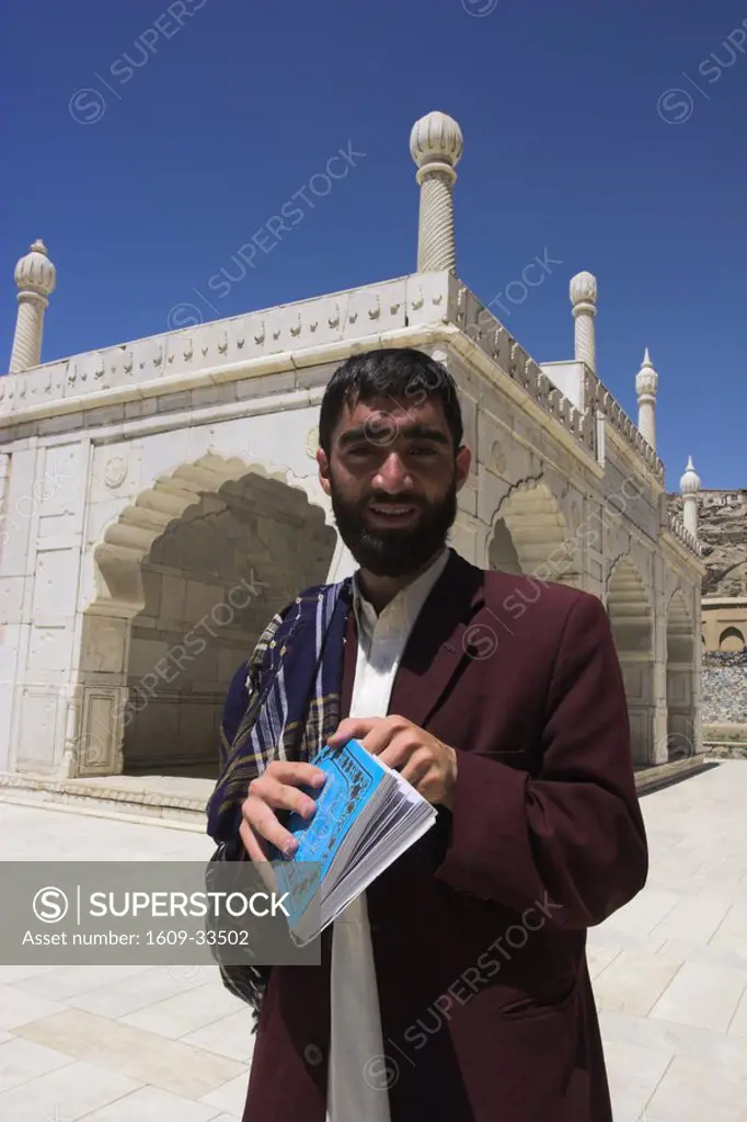 Afghanistan, Kabul, Gardens of Babur, Man reading the Koran near the white marble Mosque