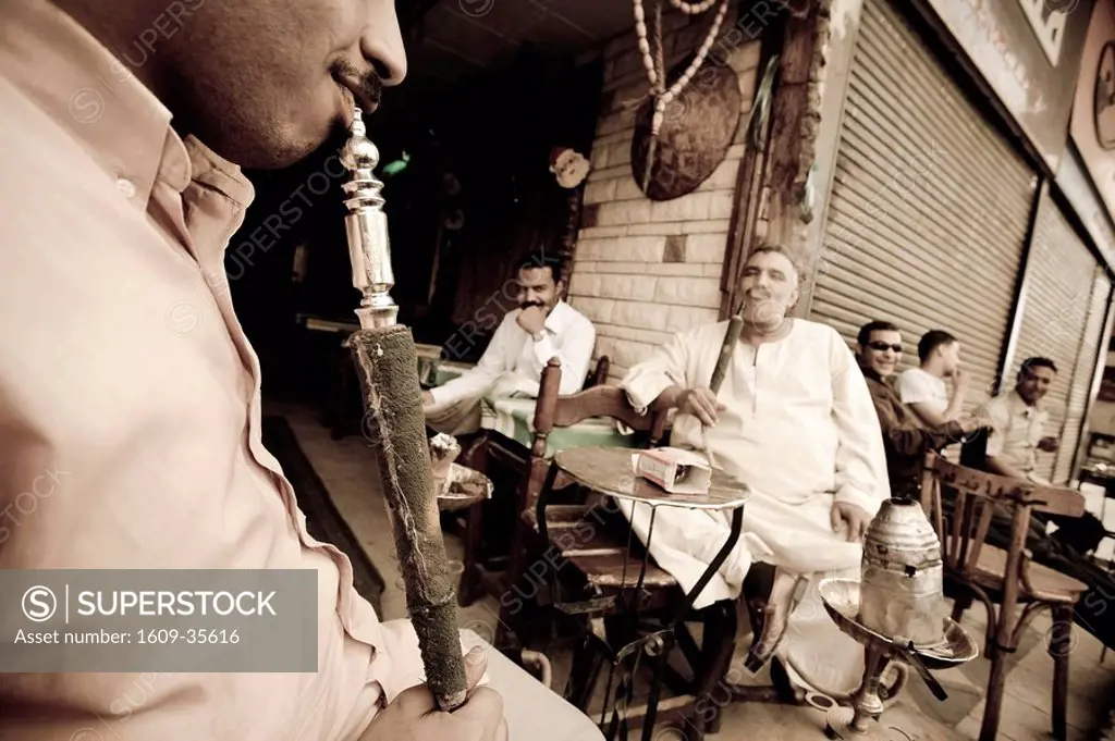 Egypt, Aswan, Old Town, Men smoking water pipe in street cafe