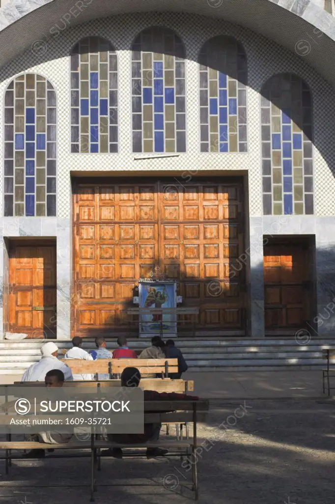 Ethiopia, Aksum People sit on benches infront of St Mary of Zion new Church