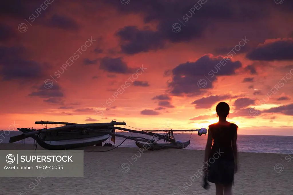Woman walking on beach at sunset, Negombo, Sri Lanka MR
