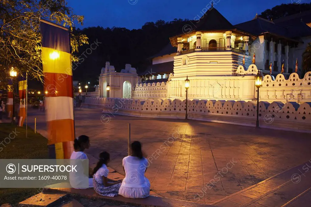 People outside Temple of the Tooth Sri Dalada Maligawa at dusk, Kandy, Sri Lanka