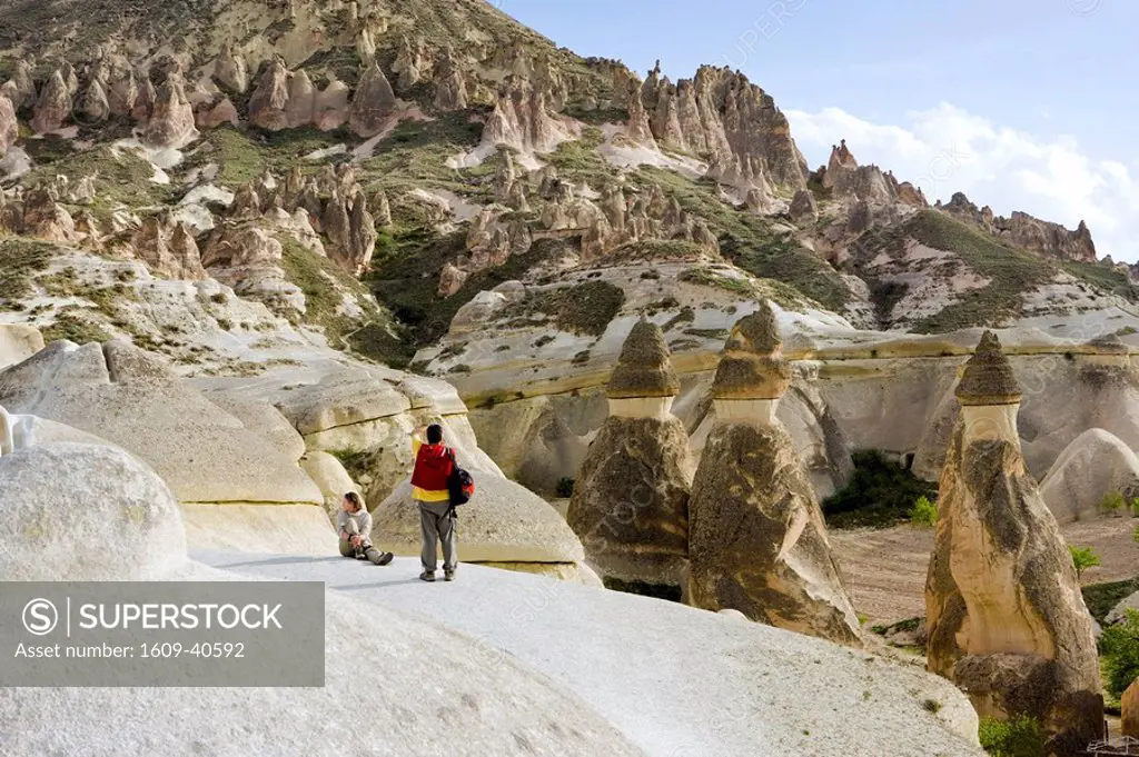 Tourists looking over Volcanic tufa formations Fairy Chimneys, Pasabag, near Zelve, Cappadocia, Turkey