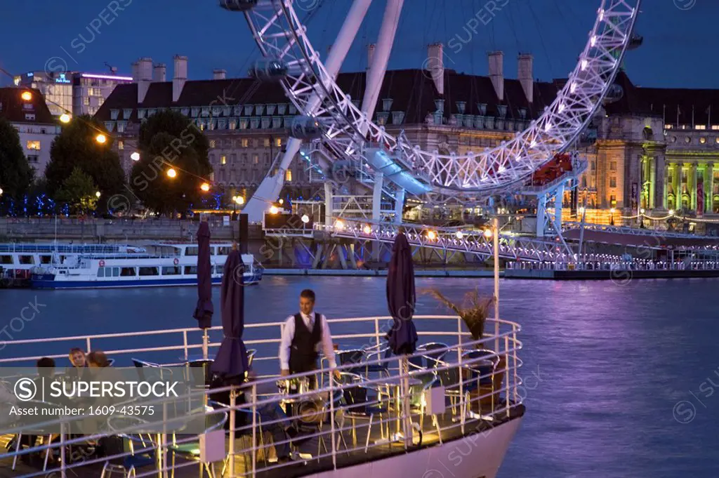 England, London, Westminster, People having drink on the deck of The Hispaniola restaurant boat, with the London Eye
