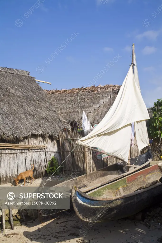 Panama, Comarca de Kuna Yala, San Blas Islands, Naranjo Chico Island, Fishing boat infront of thatched house