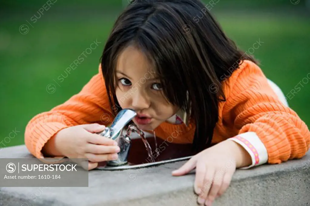 Portrait of a girl drinking water from a water fountain