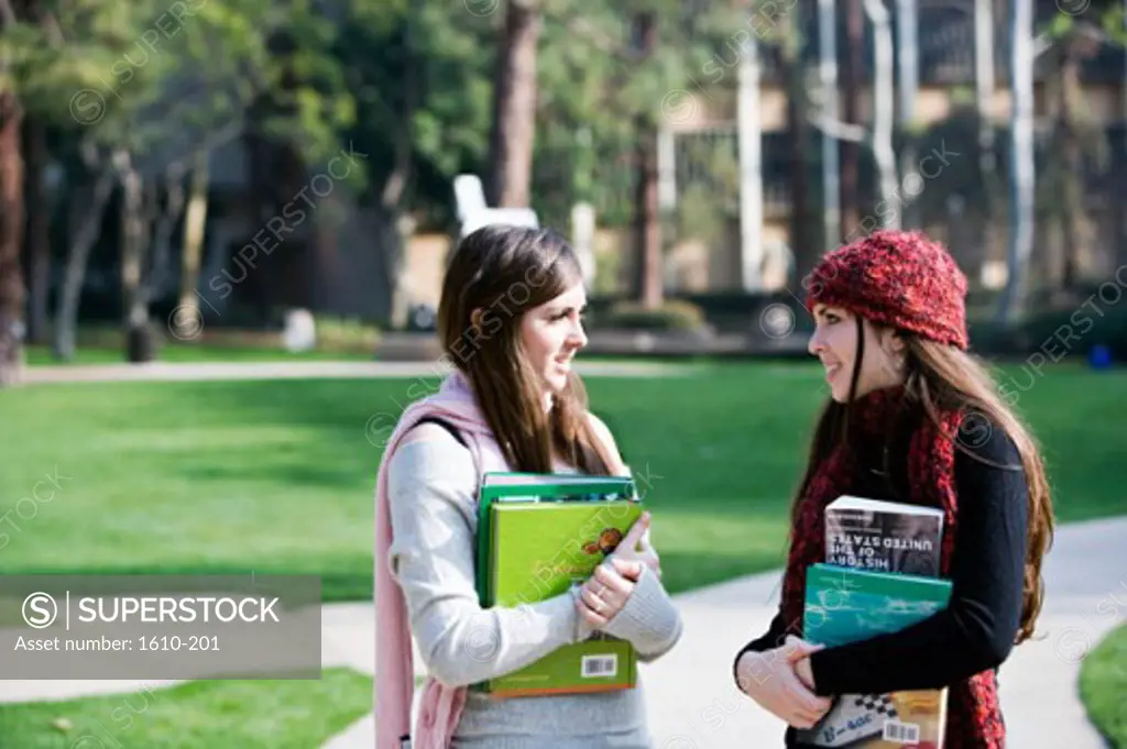Side profile of two young women talking with each other