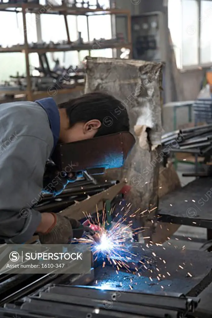 Welder welding steel sheets with a welding torch