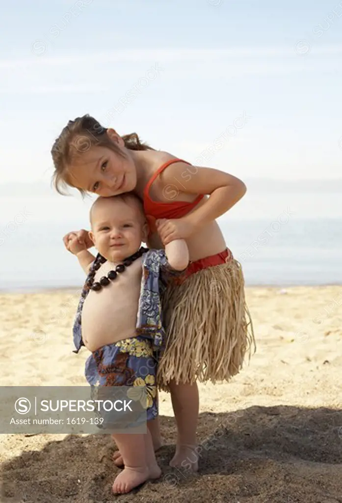 Girl and her brother in Hawaiian outfit on the beach, California, USA