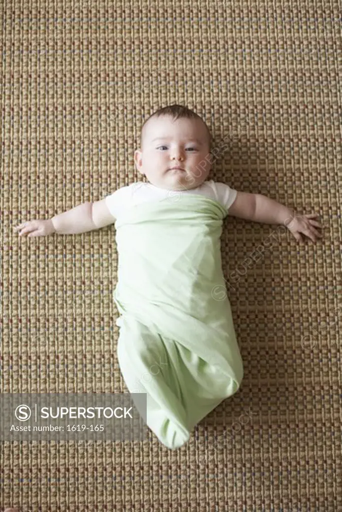 Portrait of baby girl lying on rug