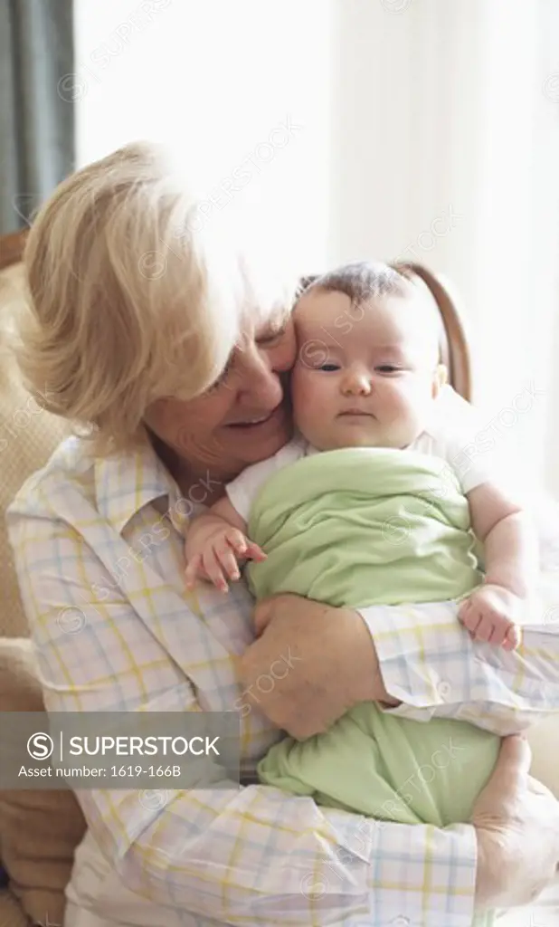 Grandmother embracing baby girl indoors