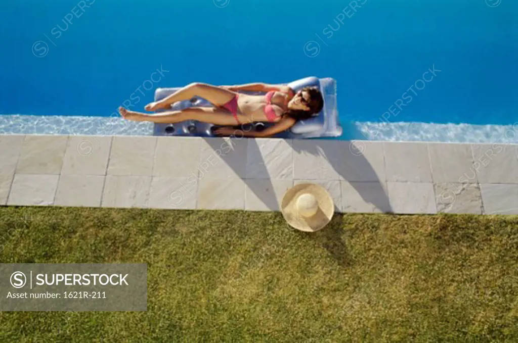 High angle view of a young woman lying on a pool raft