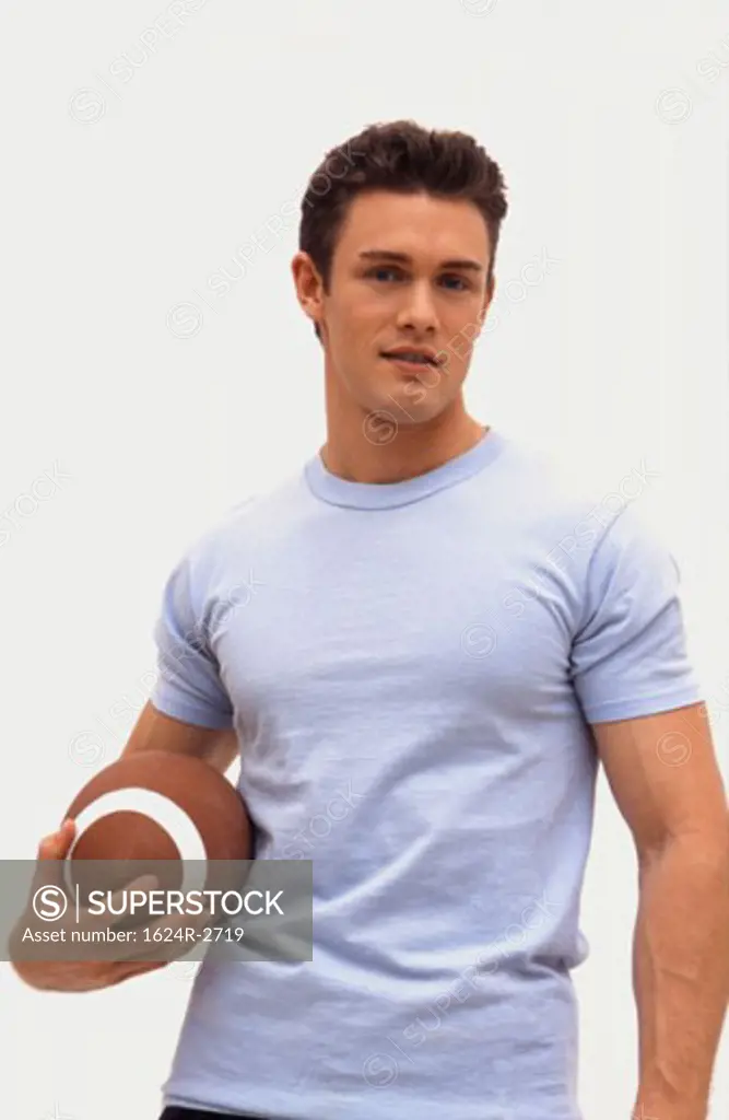 Caucasian male holding a football.