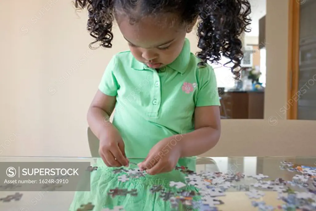 Portrait of a African American girl working on a puzzle
