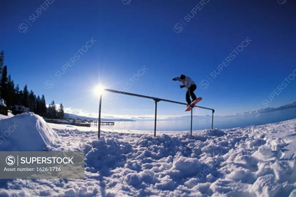 snowboarder lakeside rail slide