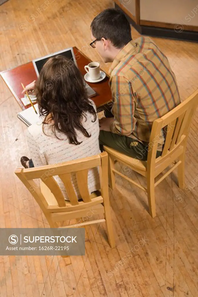 Woman and Man with Notebook and Laptop