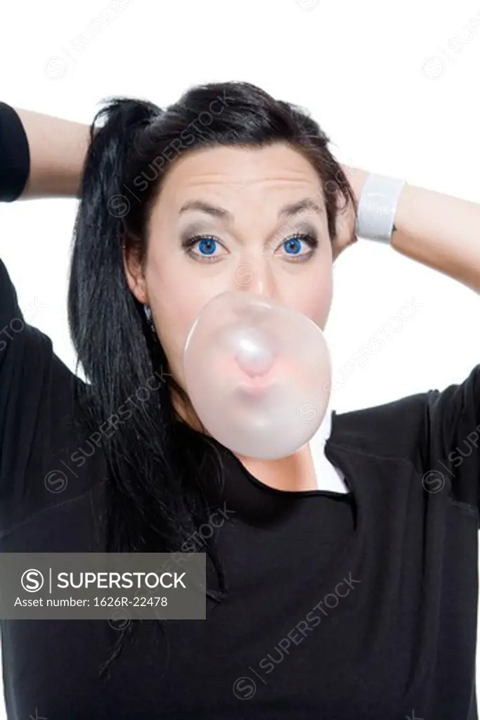 Attractive Young Woman Blowing Bubble Gum with Surprised Expression