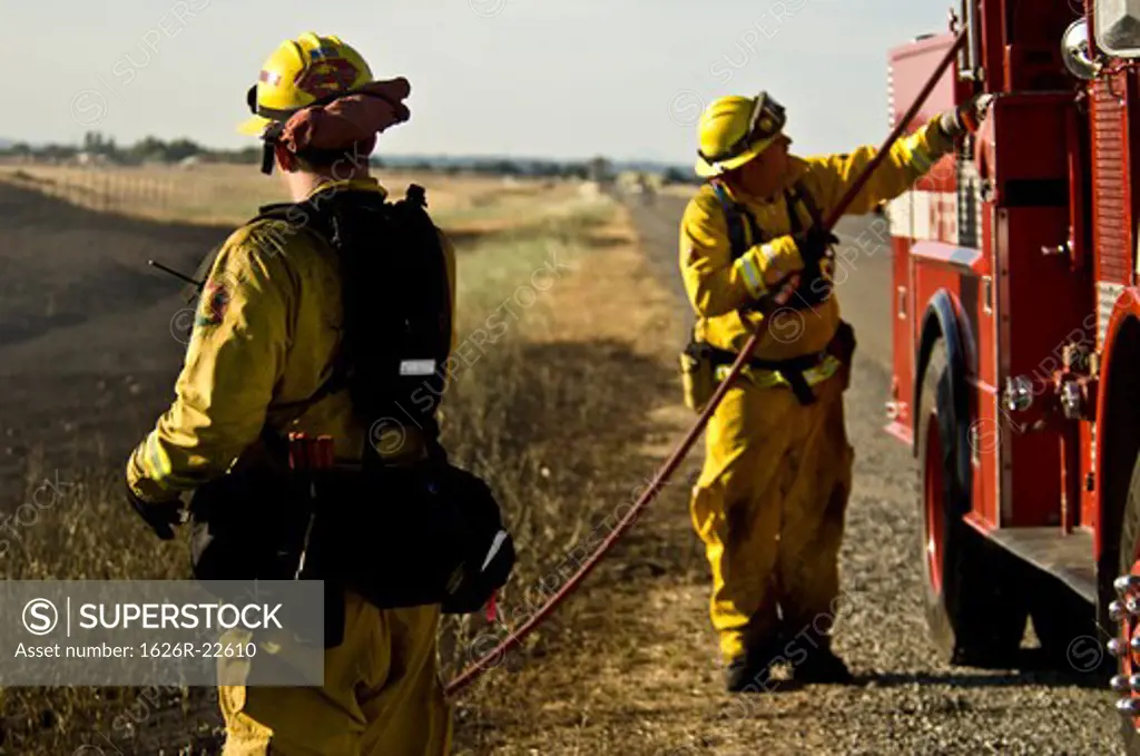 Firemen By The Side Of A Country Road