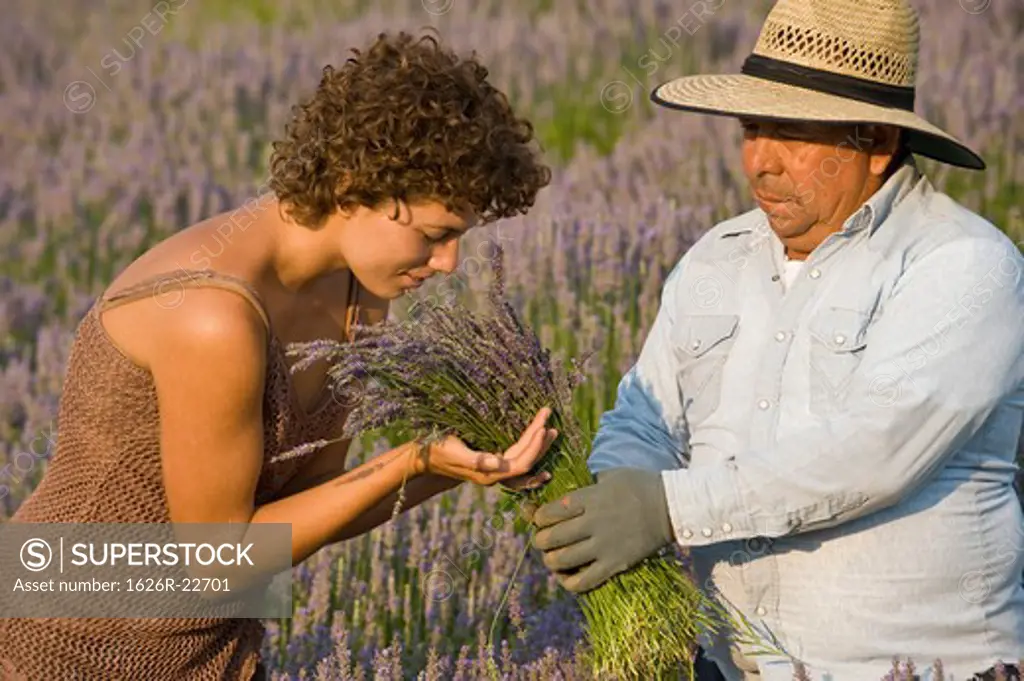 Woman Smelling Lavender Held By Worker