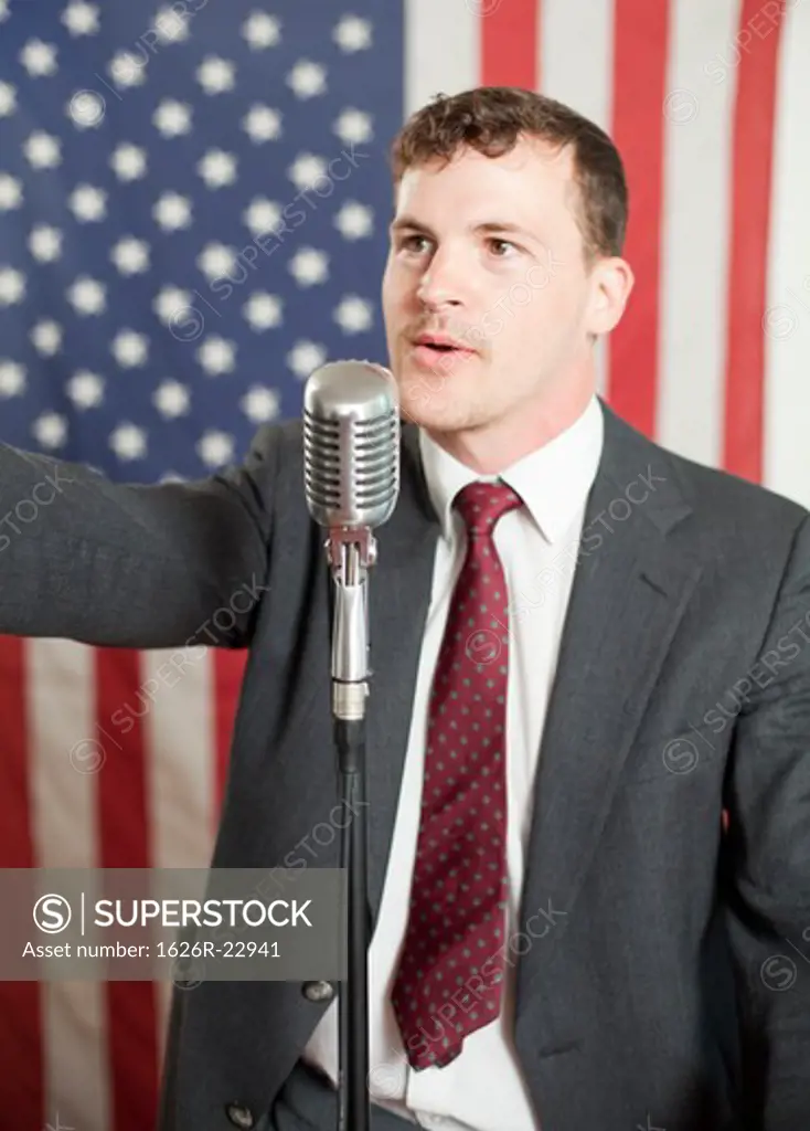 Young politician gesturing and speaking into microphone