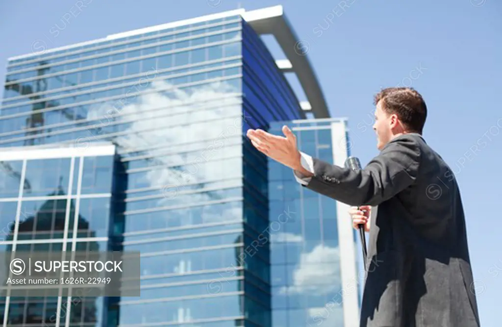 Young politician speaking and gesturing in urban setting