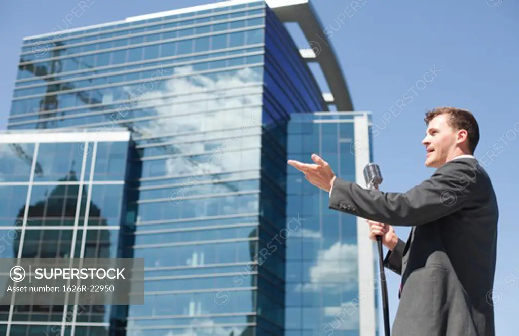 Young politician speaking and gesturing in urban setting