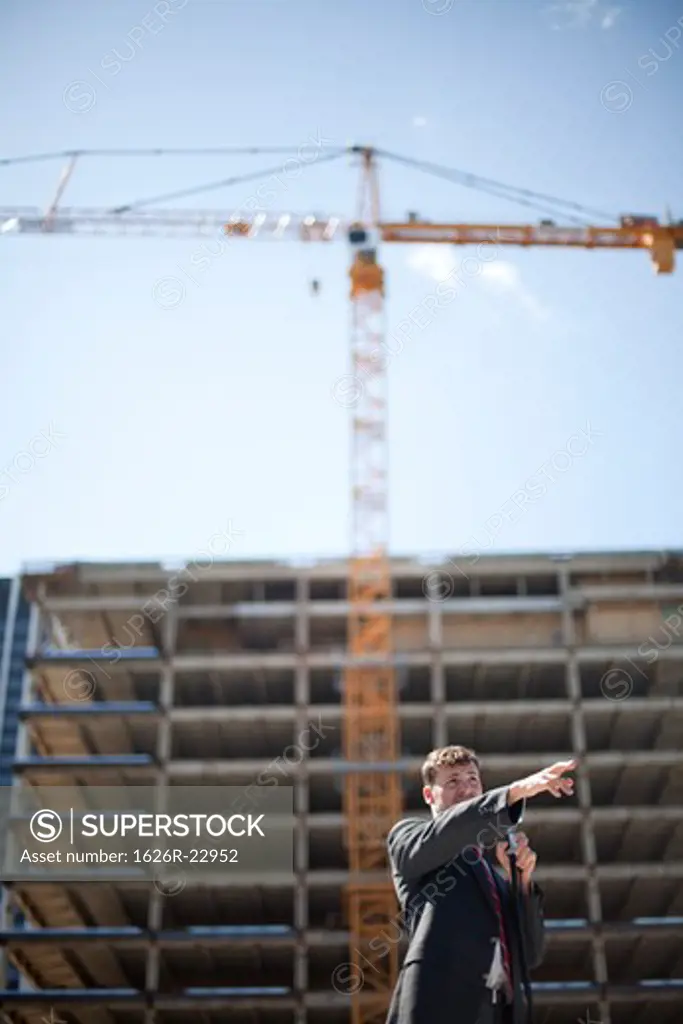 Young politician speaking and gesturing near construction site