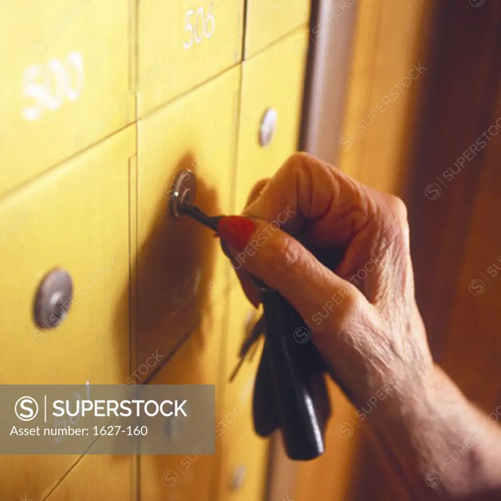 Close-up of a senior woman's hand opening a mailbox