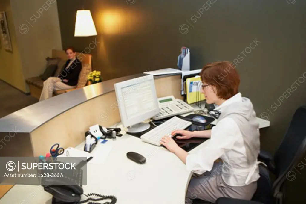 Side profile of a businesswoman working on a desktop PC in an office