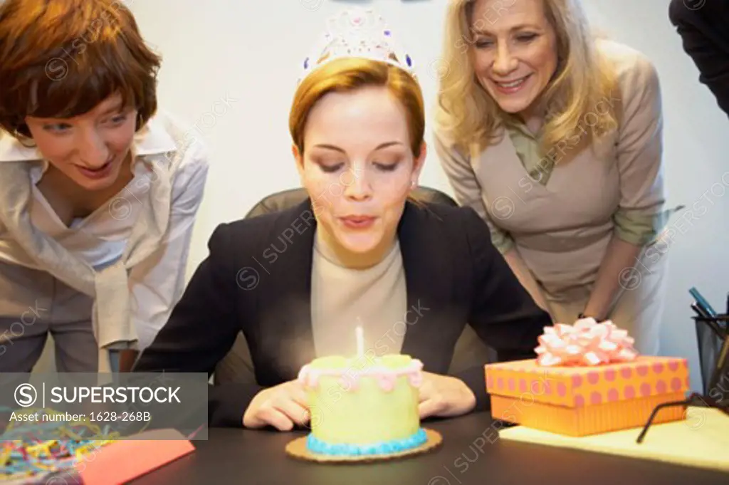 Close-up of a businesswoman celebrating her birthday with her colleagues