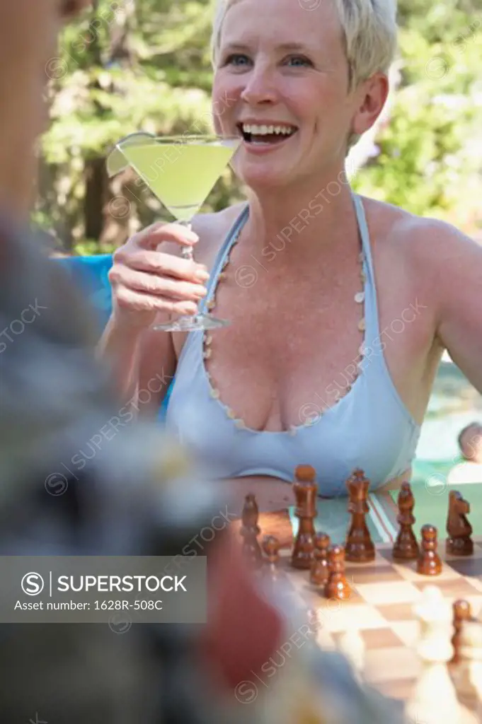Close-up of a mature woman holding a martini and smiling