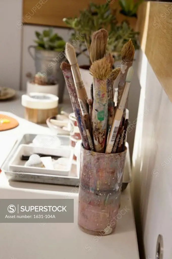 Close-up of paintbrushes and paint trays on a table