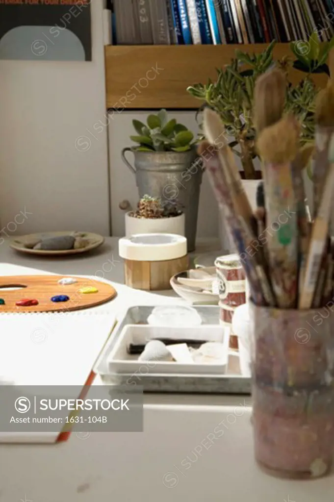 Close-up of paintbrushes and paint trays on a table