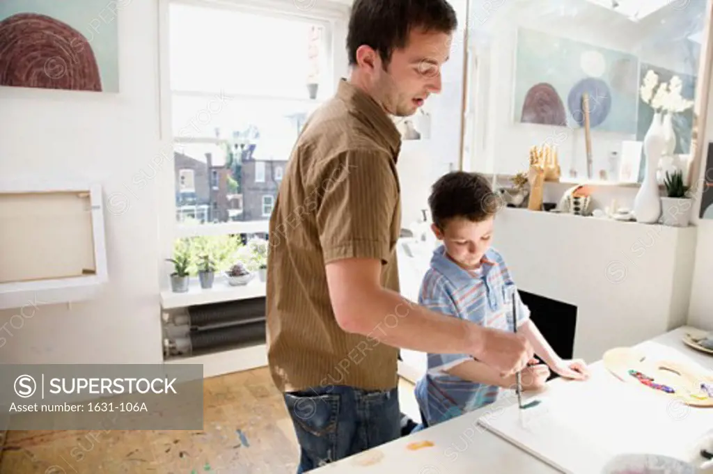 Side profile of a young man painting with his son