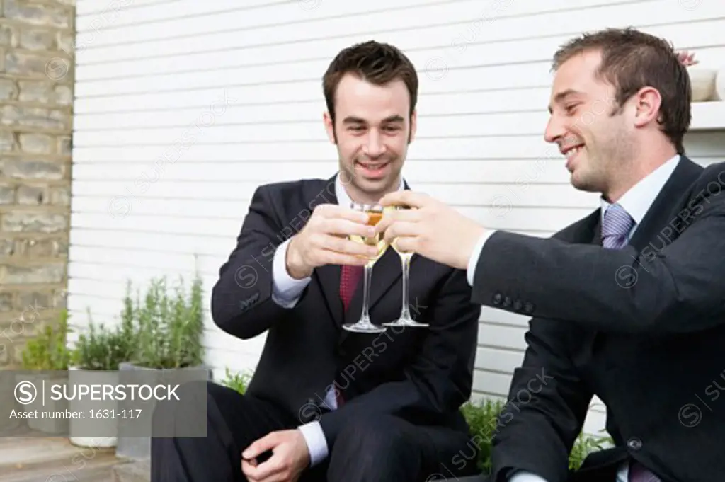 Close-up of two businessmen toasting with wineglasses