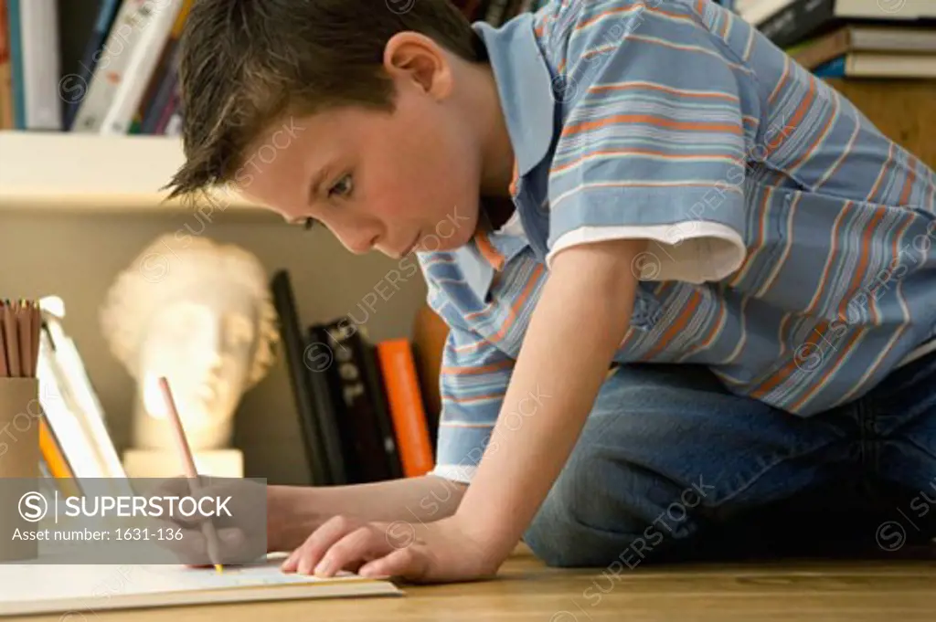 Close-up of a boy drawing on a sketch pad