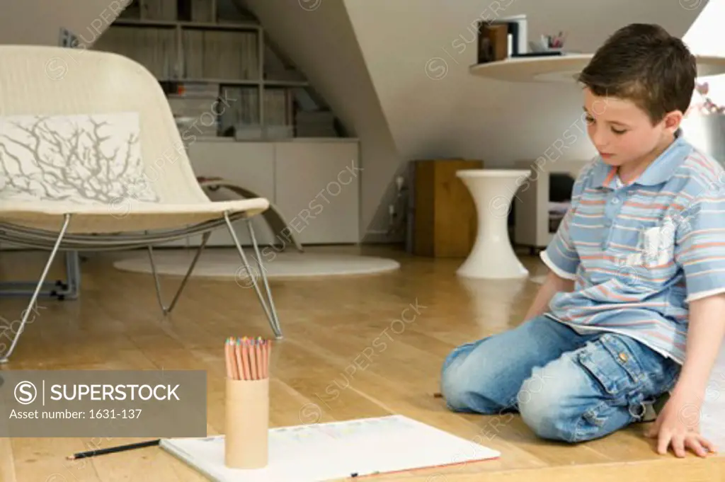 Close-up of a boy kneeling on a hardwood floor