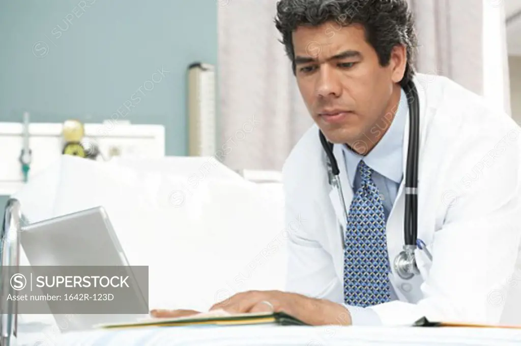 Side profile of a male doctor using a laptop