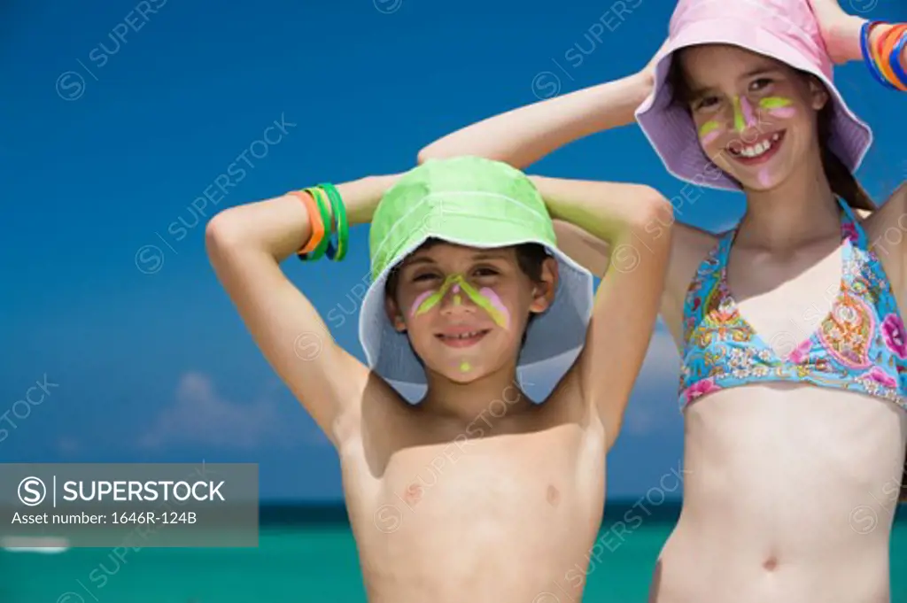 Portrait of a girl standing with her brother smiling