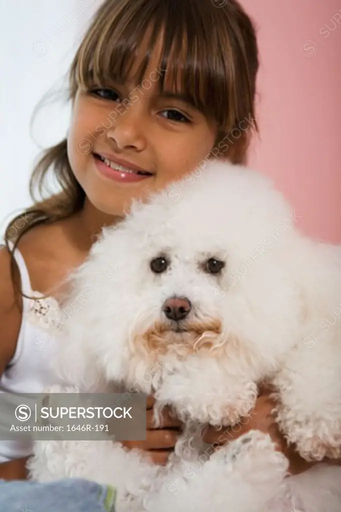 Portrait of a girl hugging her dog and smiling