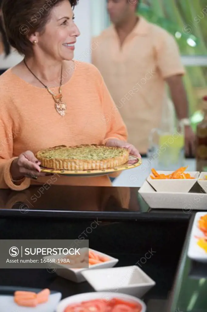 Mature woman holding a pie and smiling