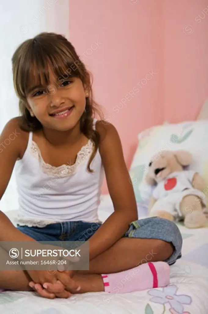 Portrait of a girl sitting in the bed and smiling