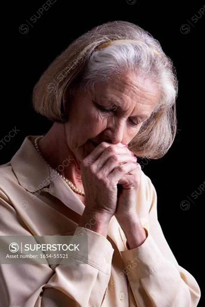 Studio. Emotional Portrait of Senior woman praying