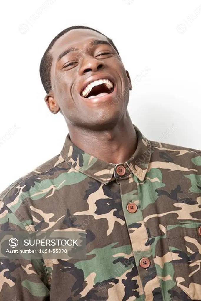London, UK. Portrait of cheerful young military soldier in camouflage clothing laughing against white background