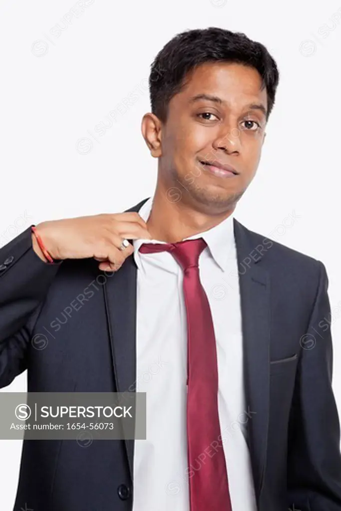 London, UK. Portrait of tired young Asian businessman against white background