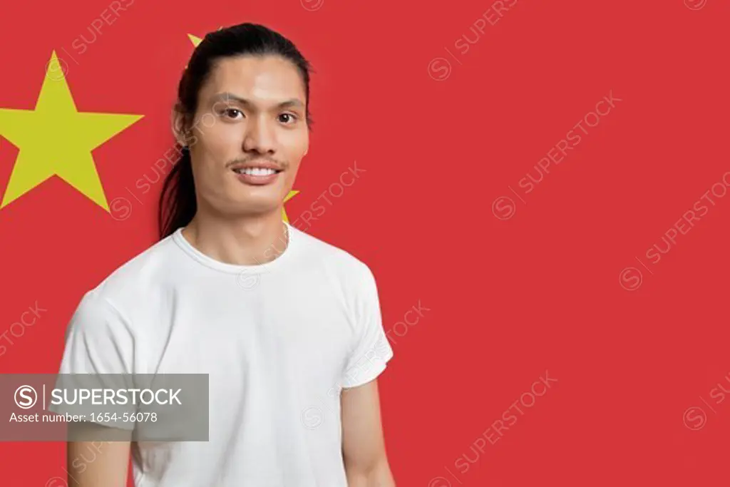 London, UK. Portrait of young mixed race man standing against Chinese flag
